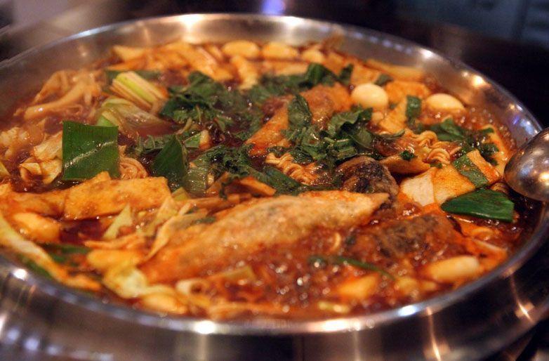 Bubbling hotpot of instant Tteokbokki at Hwa Tteok, featuring a medley of Korean staples like ramen and rice cakes.